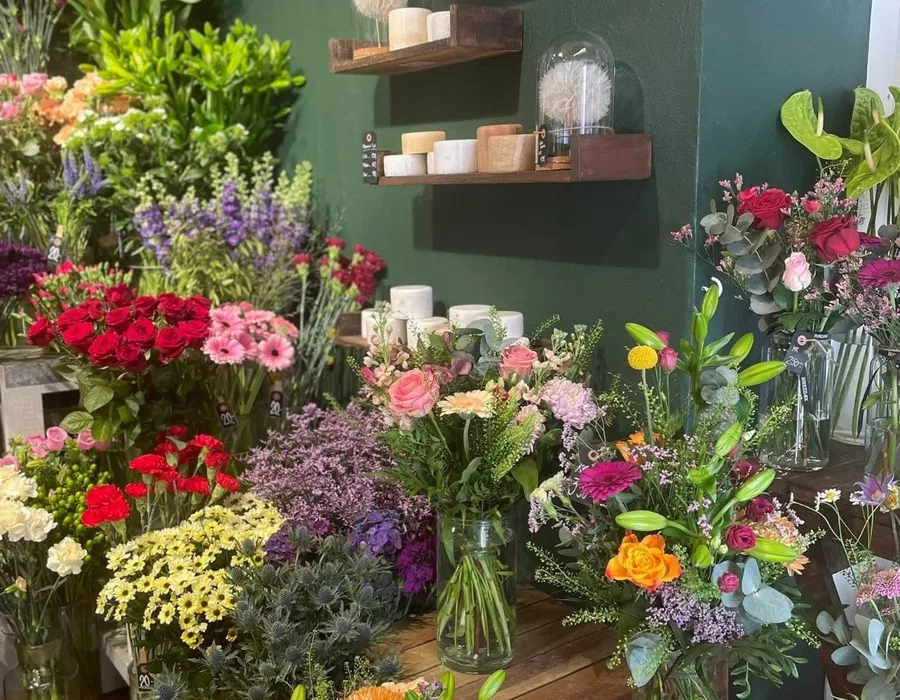 Butikken indefra med planter, lys og dekorationer på træborde